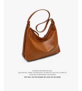 Detail view of the brown leather hobo shoulder bag showing texture, strap and minimalist design.