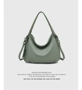 Close-up detail of sage green leather hobo shoulder bag with soft slouchy texture and straps.