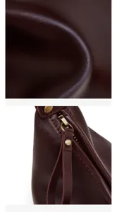 Close-up view of dark brown leather texture and metal zipper hardware detail on women shoulder bag.