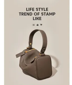 Detailed view of a stylish brown cylindrical Boston handbag featuring premium gold hardware.