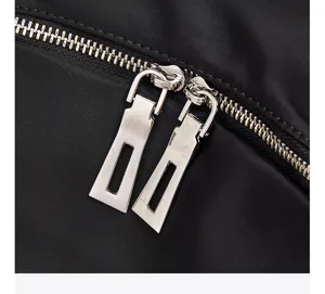 Close-up view of the smooth metal zipper pullers and durable black nylon fabric of the fashion backpack.
