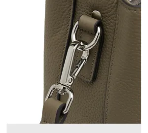 Gros plan sur la quincaillerie du fermoir en métal et le cuir souple d'un sac à main.