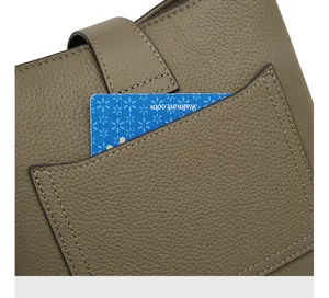 Primo piano dettagliato della tasca anteriore della borsa in pelle con cuciture rifinite.