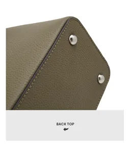 Primo piano dei dettagli della borsa da donna in vera pelle con texture e piedini in metallo.