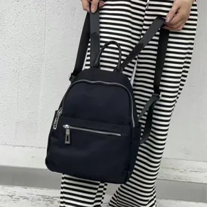 Classic black nylon backpack for women, casual daily school bookbag with zipper pockets.