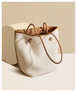 Woven bucket bag detail view, casual commuting shoulder handbag with contrast leather trim.