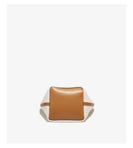 Detailed view of casual fashion bucket bag with brown leather and white canvas combination.