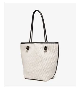 Elegant woven tote bag with black leather trim and knot details, perfect for daily commuting.