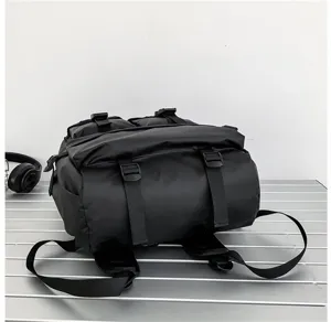 Dettaglio dello zaino nero impermeabile roll-top con tessuto resistente e cinghie regolabili.