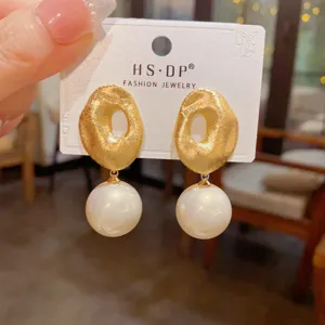 Detailansicht französischer Vintage gebürsteter Goldmetall- und Perlen-Ohrringe, Schmuck.