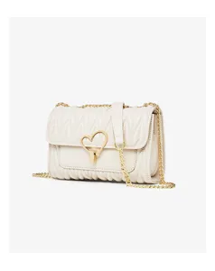 Close-up detail of quilted white leather shoulder bag with elegant gold chain and heart lock.