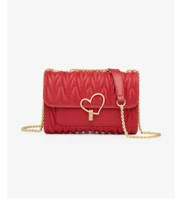 Detailed view of red quilted leather crossbody bag with chic heart lock and gold chain strap.