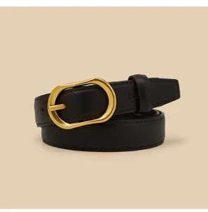 Close-up detail of the elegant black leather belt featuring a unique gold metal buckle.