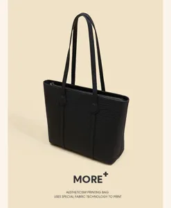 Close-up detail of black crocodile texture tote bag featuring long handles and top zipper.