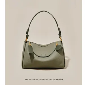 Detail shot of women's green leather pillow shoulder bag, stylish Boston handbag with dual zippers.