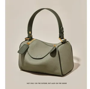 Green leather handbag detail, featuring soft litchi grain texture and gold hardware.