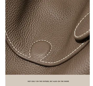 Premium leather pillow bag detail shot with contrast saddle stitching and classic taupe color.