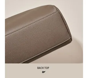 Close-up detail of women taupe leather boston pillow bag, featuring neat stitching and texture.