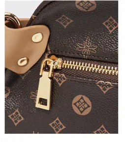 Close-up detail of vintage brown monogram pattern women shoulder bag with golden zipper hardware.