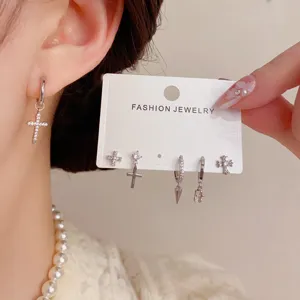 Detail shot of stylish zircon cross earrings set, featuring unique dagger designs.