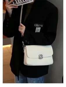 Minimalist white leather shoulder bag detail featuring stylish metal twist lock and chic look.