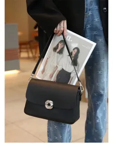 Black leather shoulder bag detail, stylish silver twist lock, premium texture, daily chic.