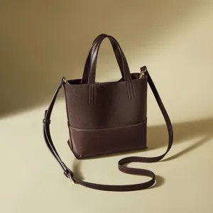 Borsa secchiello da donna marrone scuro, design in pelle e camoscio con tracolla regolabile.