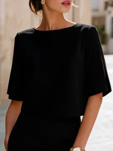 Inquadratura di dettaglio di un top nero minimalista a maniche corte con elegante spacchetto.