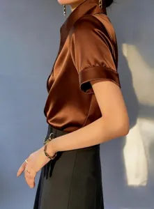 Detail shot of brown satin short sleeve shirt showing smooth fabric texture and style.