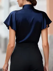Vista dettagliata di una blusa in raso blu navy con collo a imbuto e maniche a volant.