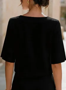 Dettaglio del top nero a maniche corte minimalista con elegante design a spacchetto.