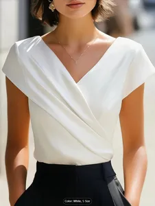 Vista detallada del elegante top blanco con cuello en V cruzado y textura de tela suave.