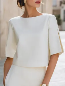 Vista dettagliata di un top minimalista bianco a maniche corte con eleganti spacchi laterali.