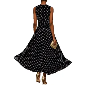Robe longue sans manches élégante à pois noirs et blancs avec une coupe trapèze flatteuse et fluide.