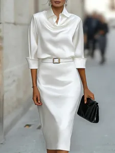Elegant white satin long sleeve blouse and skirt detail showing smooth fabric and belt buckle.