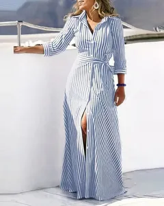 Blue white striped long sleeve shirt dress detail view on outdoor deck background.