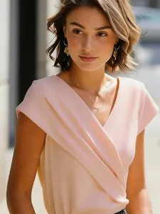 Primer plano detallado de un elegante top rosa de manga corta con cuello en V cruzado.