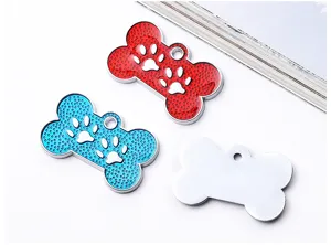 Detail view of metal bone-shaped pet ID tags in red, blue, and silver, ready for laser engraving.