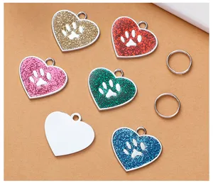 Close-up detail view of heart-shaped glitter dog pet ID tags with cute paw print and metal rings.