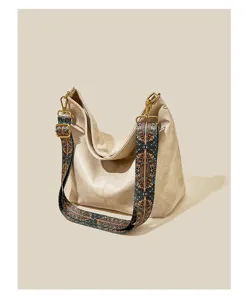 Gedetailleerd overzicht van de elegante beige schoudertas met etnische brede schouderriem.