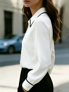 Detail view of women's long-sleeve contrast lapel shirt showcasing elegant tailoring.