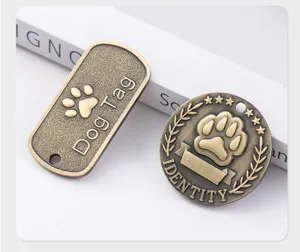 Detailed close-up of vintage bronze metal pet ID tags featuring paw prints and engraved text.
