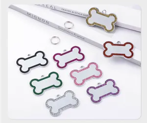 Detailed close-up of colorful glitter edge bone shaped metal pet dog ID tags with rings.