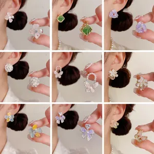Primer plano detallado de pendientes artesanales de cristal con flores y perlas.