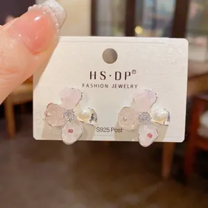 Primer plano de pendientes flores perlas cristal en tarjeta, diseño minimalista dulce.