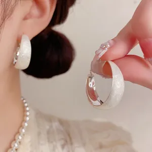 Eleganti orecchini a cerchio glitterati bianchi da donna, design chic e gioielli.