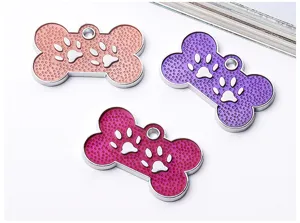 Colorful bone-shaped pet ID tags with paw print design, durable metal and enamel tags.