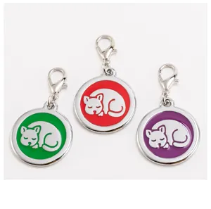 Close-up detail of metal pet ID tags with colorful enamel and sleeping cat design pendants.