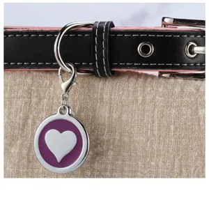 Close up detail of engraveable metal pet tag with purple heart design and leather collar.