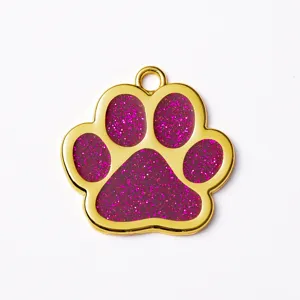 Gold zinc alloy pet ID tag with sparkling pink glitter paw print design for dogs and cats.